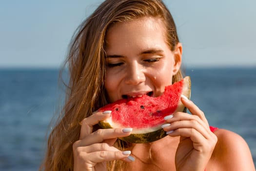 Woman with long brown hair enjoys a juicy slice of watermelon at the beach. Sunlight illuminates her face as she bites into the refreshing fruit.