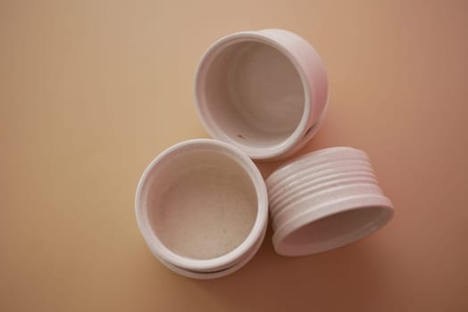 Three small, white storage containers are arranged creatively.