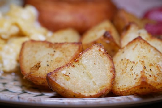 Perfectly seasoned roasted potatoes with a golden crispy exterior on a plate.