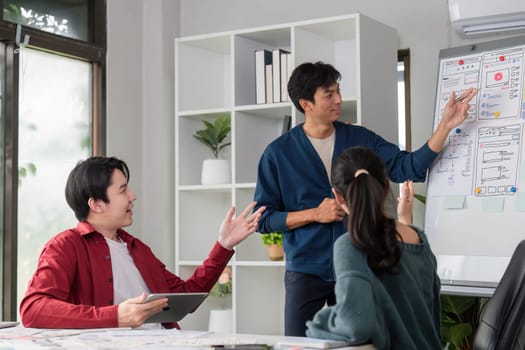 In a vibrant workspace, a leader actively engages the team, explaining design elements and promoting constructive feedback through collaboration.