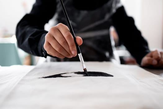 Close up of artistic hand painting on fabric with precision and skill.