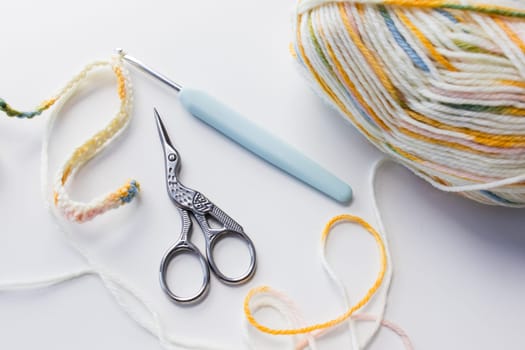 Colorful yarn with crochet hook and scissors for crafting projects.