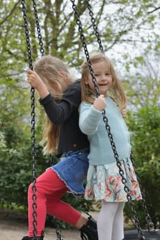 Girls riding on a swing in a park
