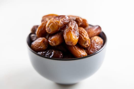 Delicious dates in a bowl on white. High quality photo