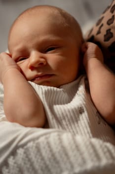 A mother lovingly holds her baby close, creating a tender moment in a warm, relaxed indoor environment with soft lighting.