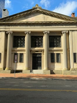 Front view of the Hampton Roads Maritime Association building with neoclassical architecture, columns, and bright morning sunlight