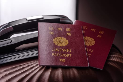 International passport of a citizen of Japan on a suitcase, departure from the airport, international travel