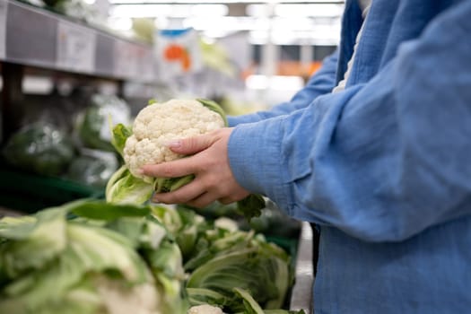 Woman's Hands Grabbing Cauliflower In The Supermarket