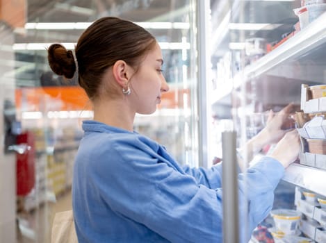 Girl Choosing Dairy Products In The Supermarket Refrigerator