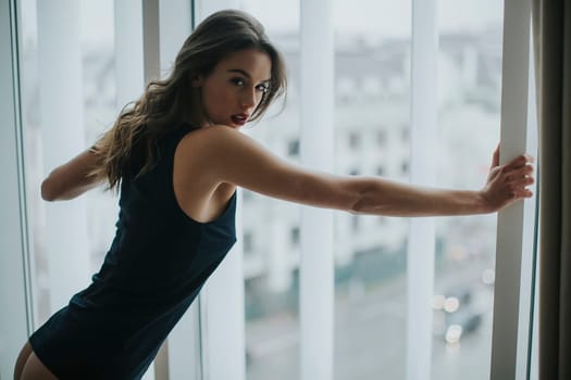 Pretty young woman by the window in the room