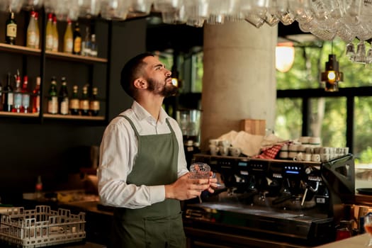 Bartender in an elegant apron meticulously arranges glassware while serving patrons in a lively café environment, highlighting craft and hospitality