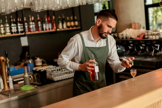 In a lively bar setting, a confident bartender mixes a fresh cocktail, showcasing his expertise with a bottle in hand, ready for the night's rush