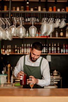 In a lively bar setting, a confident bartender mixes a fresh cocktail, showcasing his expertise with a bottle in hand, ready for the night's rush