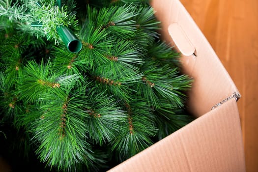 Artificial Christmas tree in cardboard box for holiday decoration.