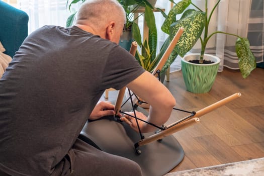 Man tightening up a bolts of the stylish chair