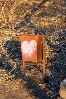 Outdoor trash bin with heart painted on it