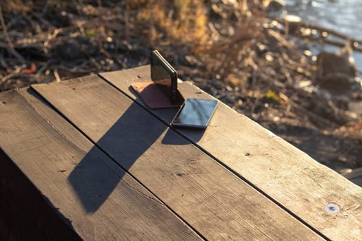 Shot of the two mobile phones on the wooden bench