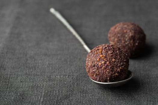 Artisan chocolate truffle candies with berry and fruit filling on dark marble background from confectionary. Handmade or handcrafted bonbons, chocolatier concept. Horizontal banner, copy space