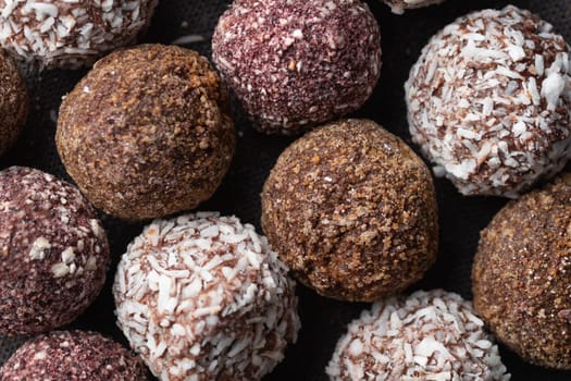 Assortment of gourmet handcrafted vegan chocolate truffle candies on dark background from premium confectionary. Bited handmade bonbon chocolatier concept. Horizontal banner with copy space