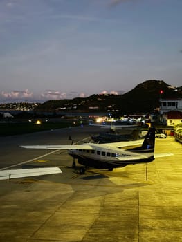 Small plane at Gustaf III Airport in St. Barts at dusk, November 20, 2023. Scenic evening view of a small passenger plane on the tarmac at a Caribbean island airport.