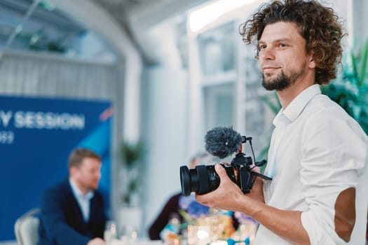 Photographer with a digital camera in his hands stands in a restaurant and looks away. High quality photo