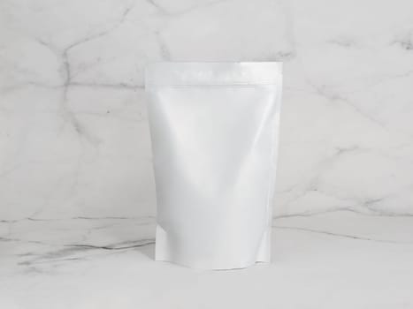 White zipper bag on marble background. Blank packaging white zipper pouch on white marble background ready for food product packaging design mock-up