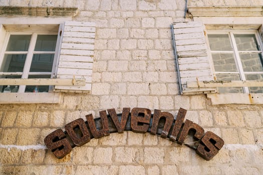 Inscription in a semicircle on the old stone facade of the building. Caption: Souvenirs. High quality photo
