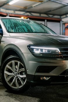Large SUV with headlights on stands at a car wash. Cropped. High quality photo