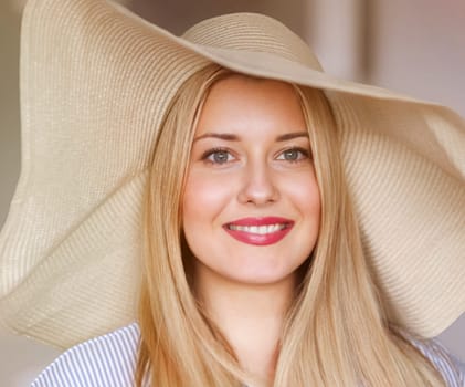 Woman, fashion and summer country charm, blonde beauty and elegance in wide brimmed beach hat. Feminine allure, timeless style and graceful glow. Smile, straw hat and blue striped blouse, natural lighting and effortless charm, fashion look idea