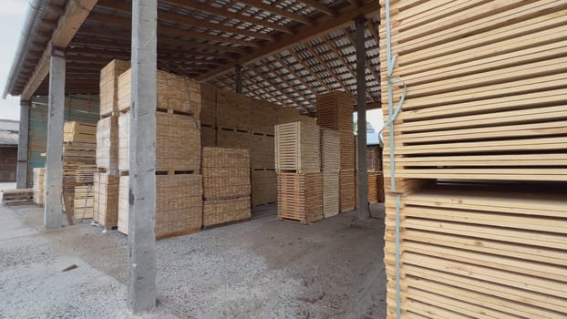 Wooden boards and planks are stacked and stored in a warehouse, drying and waiting for further processing
