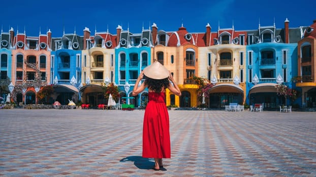 female tourist traveler in a Vietnamese hat Non La takes in sights on Vinpearl Island at VinWonders Amusement Park in Nha Trang at summer vacation in Asia. Travel and tourism in Vietnam