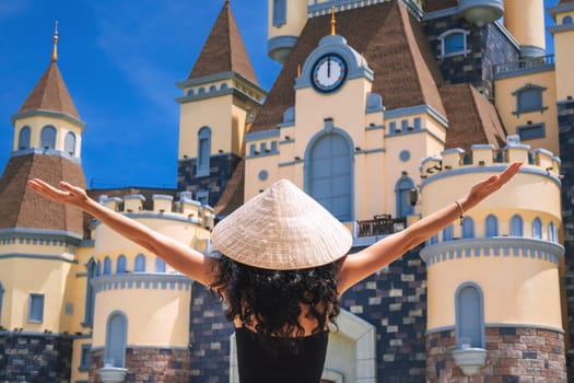 woman tourist traveler in Vietnamese hat Non La on at castle on Vinpearl Island at VinWonders Amusement Park in Nha Trang at summer vacation in Asia. Travel and tourism in Vietnam