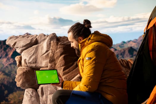 Trekker takes in the panoramic landscape next to isolated mockup screen, where the peaceful mountain scenery and open sky symbolize adventure and perseverance. Wanderlust with tech.