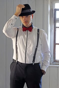 A man in 20s retro style with shirt, suspenders and hat