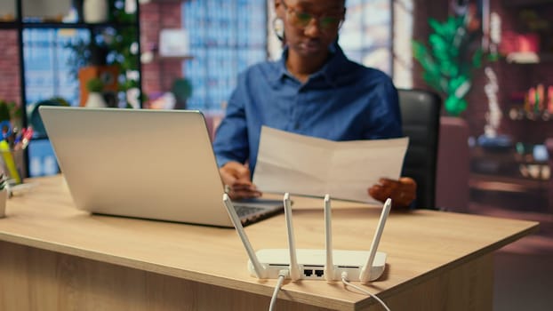 Young woman struggling with weak internet connection at home, pulling out LAN cable and adjusting Wi Fi settings to restore the signal. Female freelancer with technical issues. Camera A.