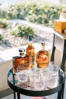 Bottles of whiskey stand on the table next to the glasses. High quality photo