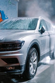 Wet soap suds running down the car at the car wash. High quality photo