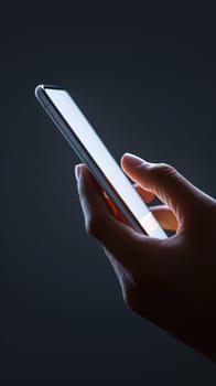 A hand holding a cell phone on blank white screen with a black background..