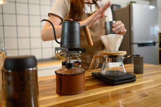 Close up of pour over coffee setup with kettle and dripper in home kitchen.