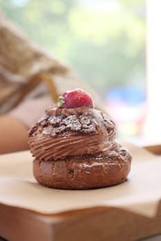 Delicious chocolate pastry topped with a fresh strawberry sits invitingly.