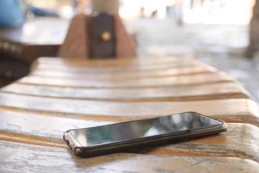 smart phone lost concept. left on park bench .