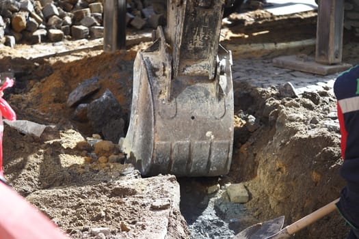 Heavy machinery digging into the ground at a busy site.