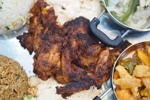 Delicious grilled chicken accompanied by fluffy rice and fresh vegetables.