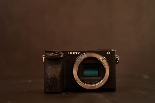 Sony A6500 mirrorless camera body stands on a black table. High quality photo