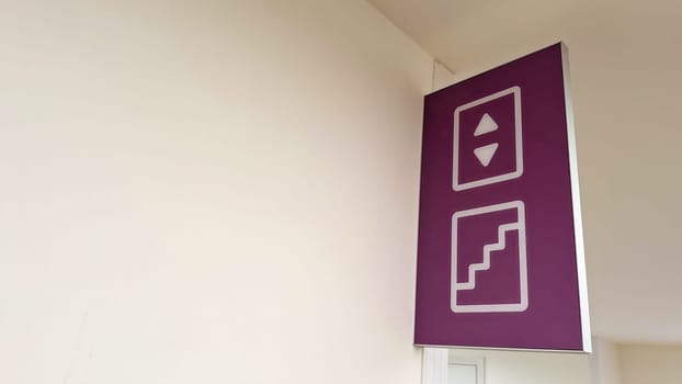 Purple elevator and staircase sign interior directional guidance.