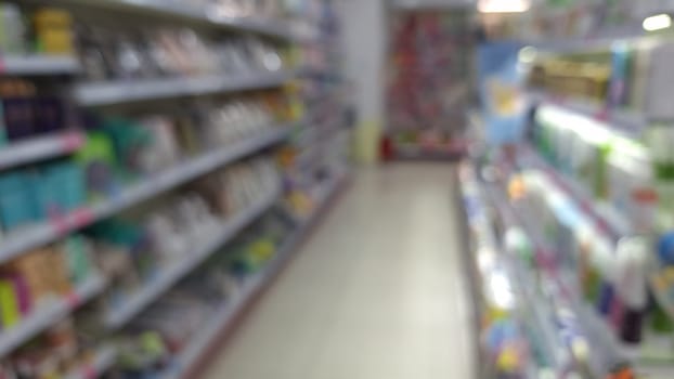 Blurred view of a store aisle with various products on shelves.