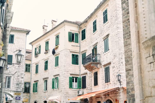 Ancient stone houses with green shutters on the windows on narrow streets. Kotor, Montenegro. High quality photo