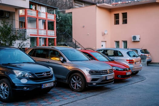 Cars stand in a row in the parking lot in the yard. High quality photo