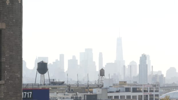New York City, United States - 3 Sept 2023: Manhattan downtown financial district skyline cityscape. World Trade Center skyscraper. Rooftop water tower, tank on roof. Industrial buildings in Queens.