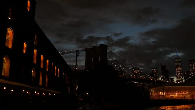 New York City, United States - 11 Sept 2023: Brooklyn Bridge, Manhattan downtown skyline cityscape. Waterfront Pebble Beach, carousel in Dumbo USA. Dramatic twilight dusk. Evening sky, Time Out Market